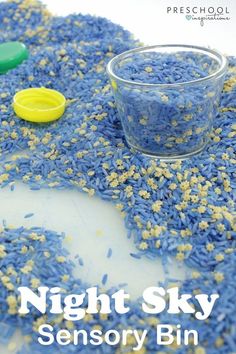 blue and yellow sprinkles in a bowl next to a small glass cup