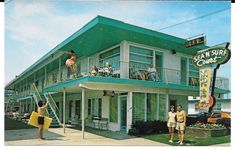 two men are standing on the balcony of a motel