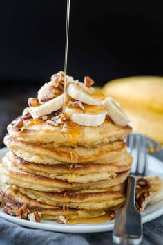 a stack of pancakes topped with bananas and syrup