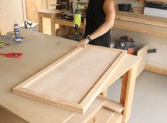 a man working on some wood in his workshop