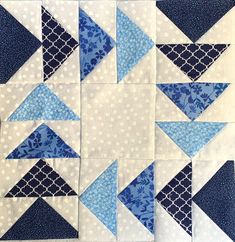 a blue and white patchwork quilt with several different triangles on it's sides