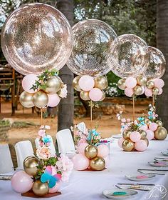 a table topped with lots of balloons and flowers