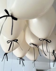 white balloons tied with black ribbon hang from the ceiling