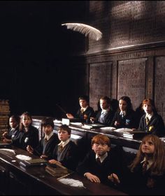 a classroom full of children sitting at desks with books and papers in front of them