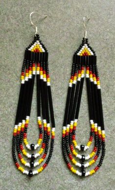 two pairs of beaded earrings with black and yellow beads on the ends, hanging from hooks