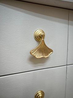 two drawers with gold handles and knobs on each drawer, one has a shell shaped handle