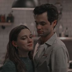 a man standing next to a woman in a kitchen