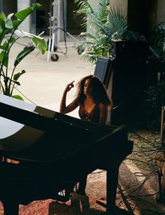 a woman sitting at a piano in the sun