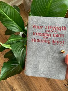 someone is holding up a book that says, your strength will be in keeping calm showing trust