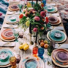 a table set up with plates and place settings for an outdoor dinner party or picnic