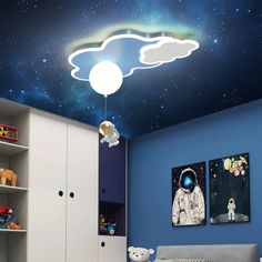 a bedroom with blue walls and a ceiling painted with an image of the moon and stars