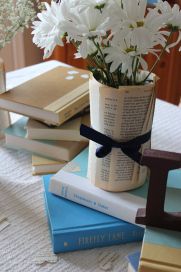 flowers in a vase sitting on top of books