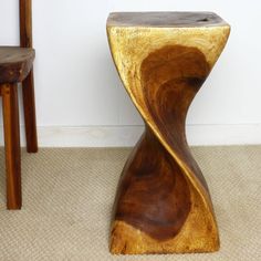 a wooden stool sitting on top of a carpeted floor