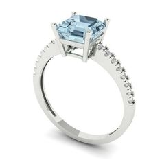 an aqua blue topazte and diamond engagement ring with white diamonds on the sides