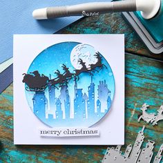 a christmas card with a santa sleigh flying over the city