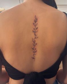 the back of a woman's neck with leaves on it