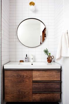 a bathroom with a sink, mirror and towel rack on the wall next to it