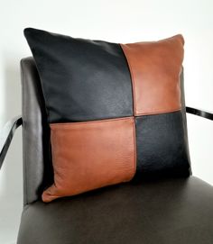 a black and brown pillow sitting on top of a chair