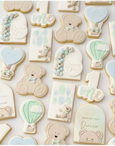 baby shower cookies with teddy bears, hot air balloons and other personalized items on them