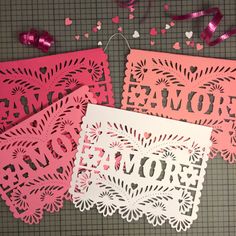 three laser cut cards with pink and white paper on them, one has the word mom