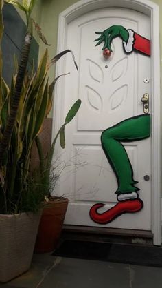 an image of a door with the grin's head painted on it and plants in pots