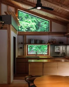 a kitchen with wooden cabinets and an open window above the countertop, along with a ceiling fan