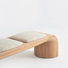 a wooden bench with two white pillows on it's seat cushion and back rest