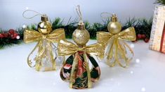 an ornament in the shape of two angel's with gold bows and bells