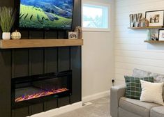 a living room filled with furniture and a flat screen tv mounted on the wall above a fire place