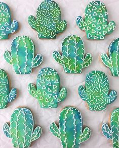 decorated cookies with green and white designs are arranged in the shape of cacti