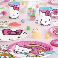 hello kitty birthday party supplies including plates, cups and napkins on a pink tablecloth