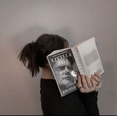 a woman reading a book with her head in her hands