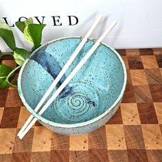 two chopsticks sticking out of a blue bowl