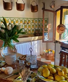 the table is covered with lemons and other food on it, along with flowers in a vase