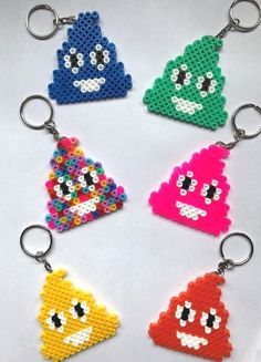 four different colored lego key chains with faces and eyes on each one, all made out of plastic beads