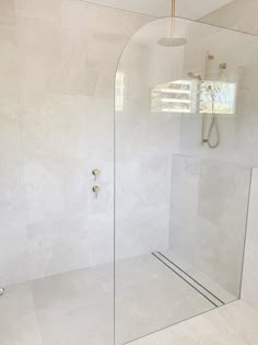 a glass shower door in a white bathroom