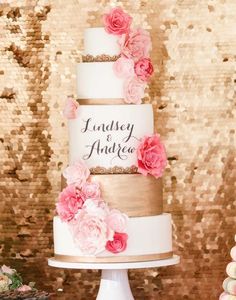 a three tiered wedding cake with pink flowers on top