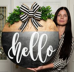 a woman holding up a sign that says hello