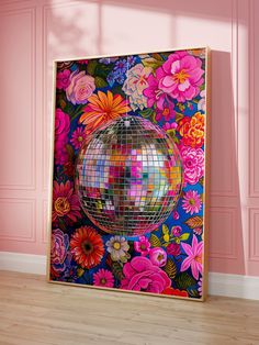 a mirror ball is on the floor in front of a pink wall and wooden floors