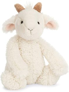 a white stuffed animal with horns on it's head and legs, sitting in front of a white background