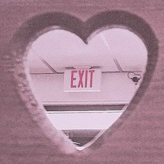 a heart shaped window with an exit sign in the middle