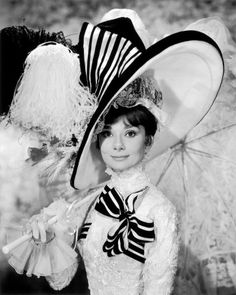 black and white photograph of woman wearing large hats