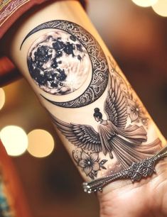 a woman's arm with an angel and the moon tattoo on her left forearm