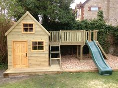 a small wooden play house with a slide