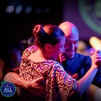 a man and woman are dancing together on the dance floor at an event with bright lights in the background