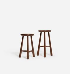 two wooden stools sitting next to each other