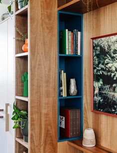 the bookshelf is made out of wood and has blue shelves with books on them