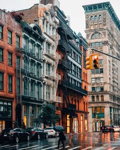 a traffic light sitting in the middle of a street next to tall buildings with balconies on them