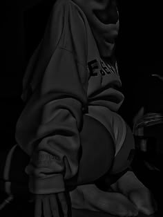 a black and white photo of a person wearing a hoodie with their hands on the ground