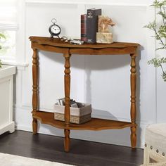 a small wooden table with books on top and a clock sitting on it's shelf